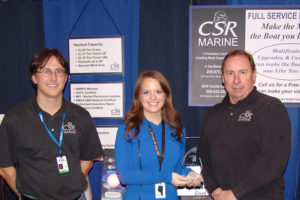 Nigel Barron, left and Scott Anderson, right, accept the  Best Show Personnel award from Boat Show Manager Kim Smith.