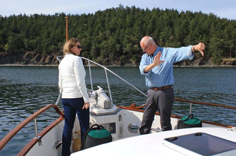 Brian Pemberton walks Annette through the hand signals that tell the captain how much chain to lay and where to move the boat.